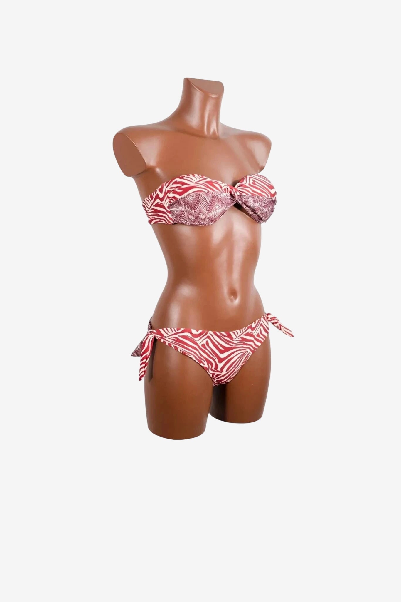 Bikini a fascia rosso e bianco con stampa zebrata e geometrica su manichino.