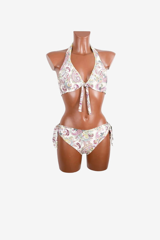 A white bikini with a colorful paisley print, featuring a halter top and side-tie bottoms.