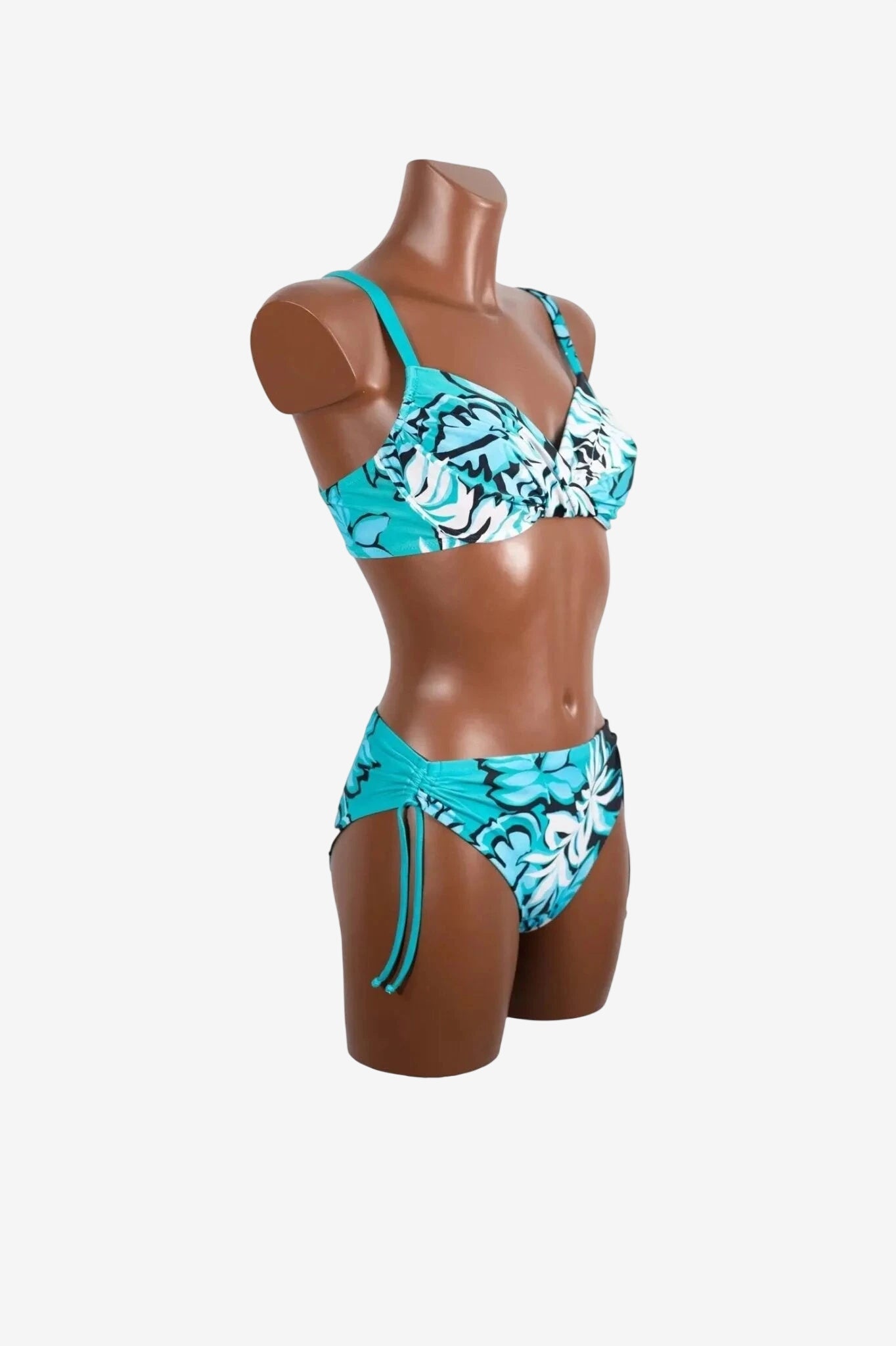 A turquoise bikini set with a black and white floral print displayed on a mannequin.