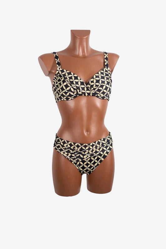 A black and beige patterned bikini set with a twisted front top on a mannequin.