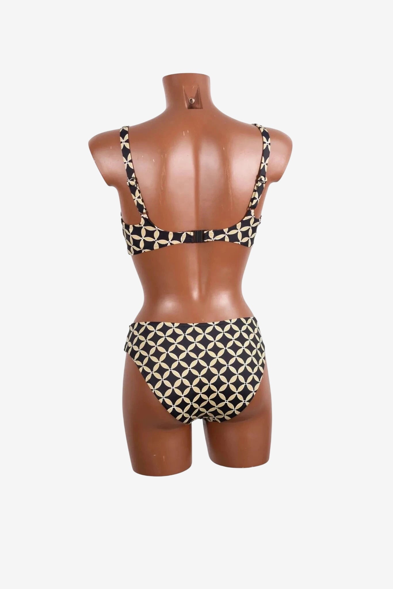 A black and beige geometric print bikini set with an underwire top shown on a mannequin.