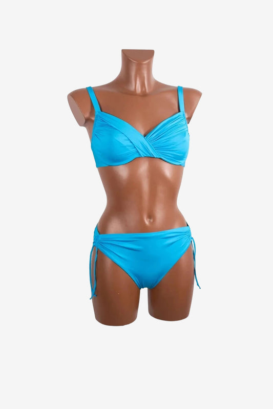 A bright blue bikini set with a ruched, wrap-style top and tie-side bottoms on a mannequin.