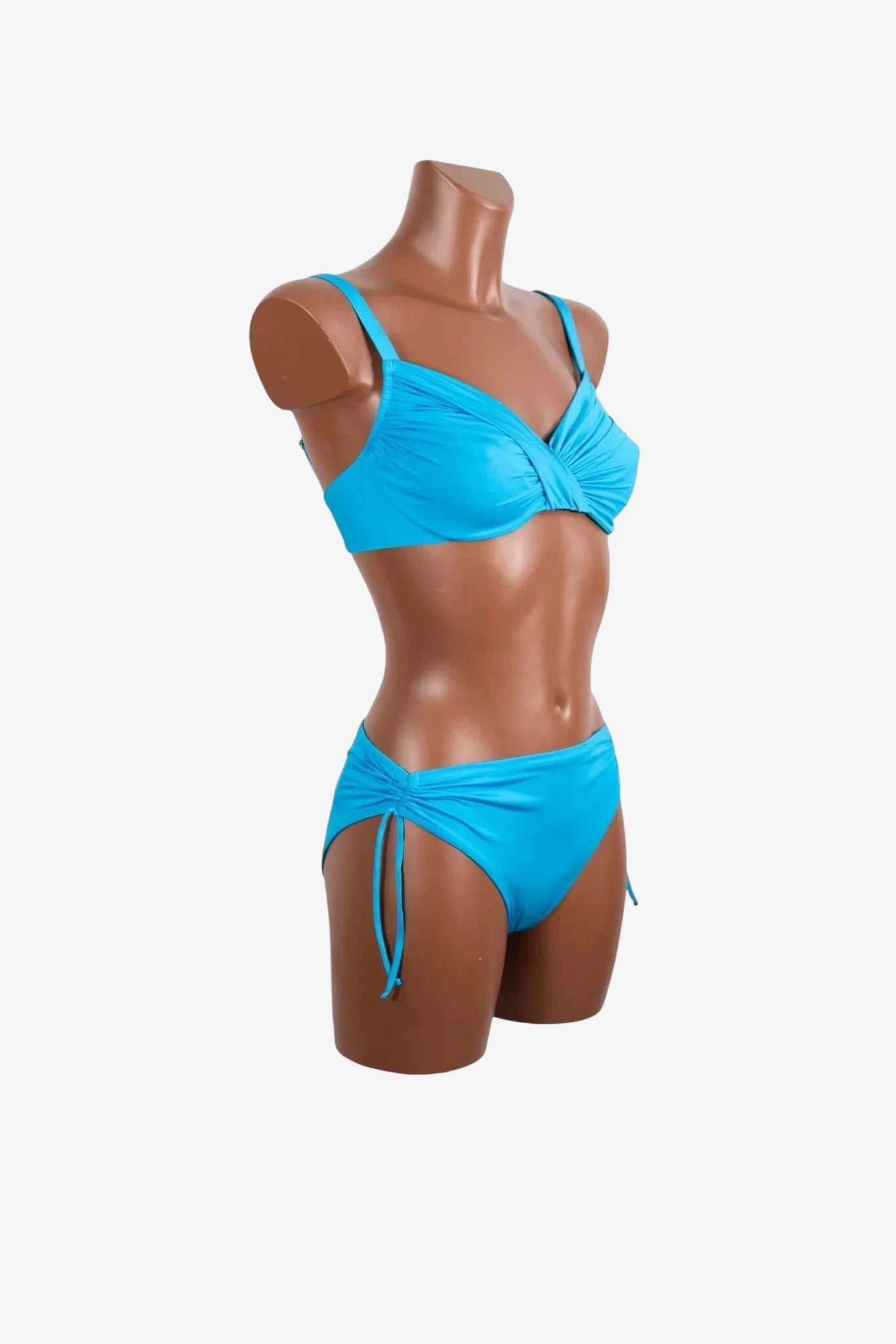 A bright blue bikini set with a ruched underwire top and matching side-tie bottoms on a mannequin.