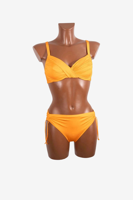 A bright orange bikini set with a ruched, wrap-style top and side-tie bottoms on a mannequin.