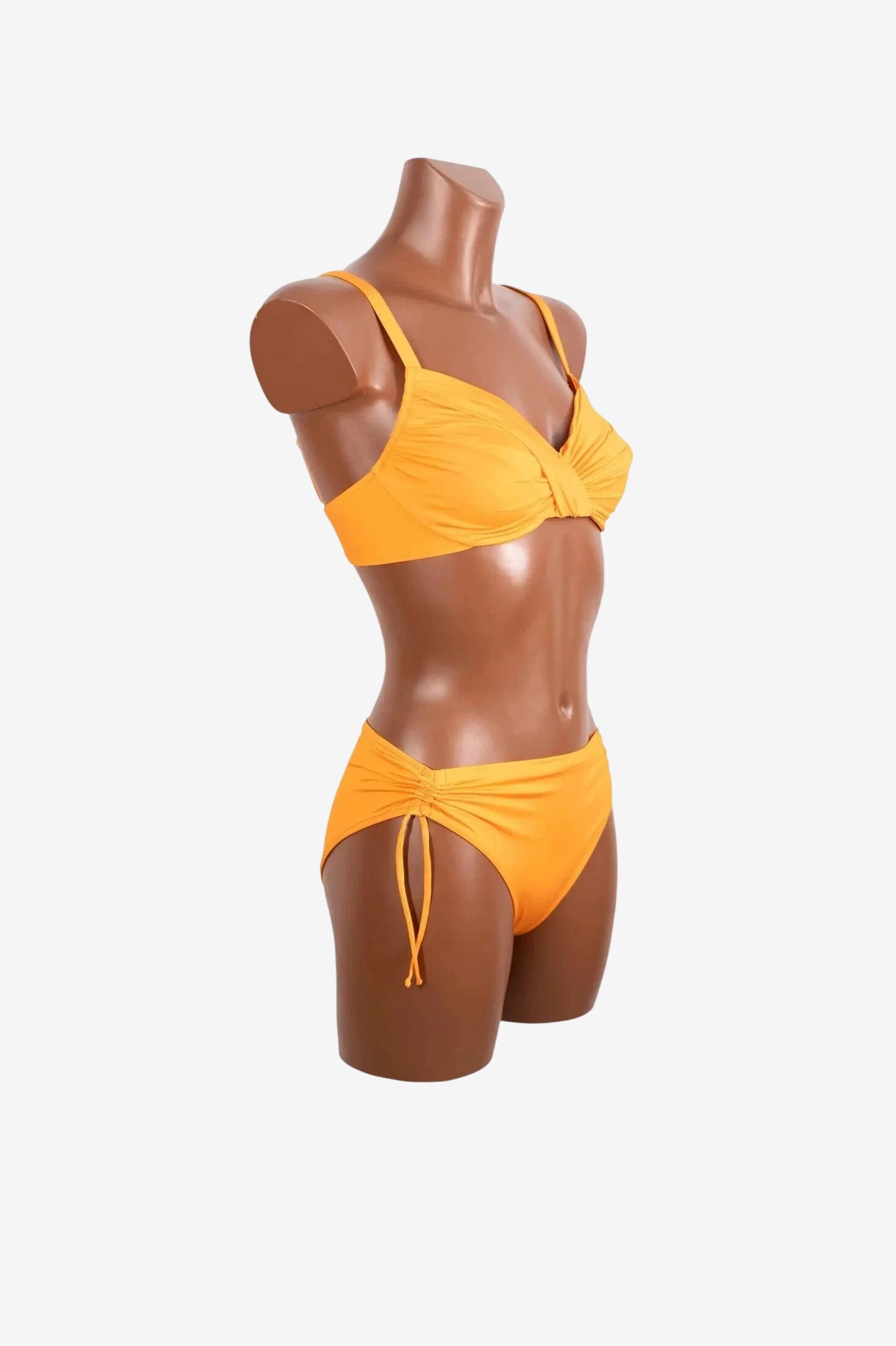 A bright yellow bikini set with a ruched underwire top and matching side-tie bottoms on a mannequin.