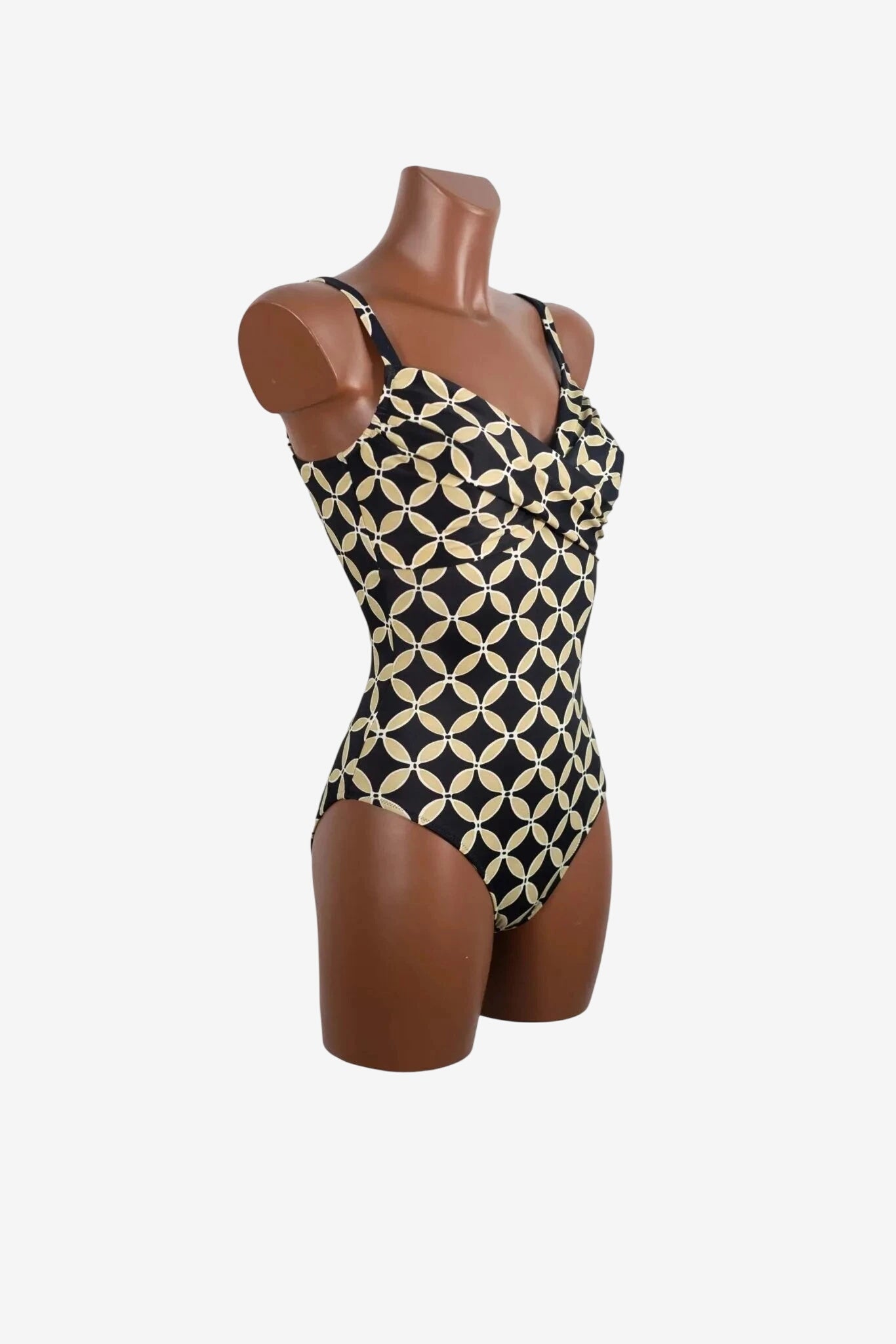 Costume intero Roidal con fantasia geometrica color sabbia e beige su fondo nero.