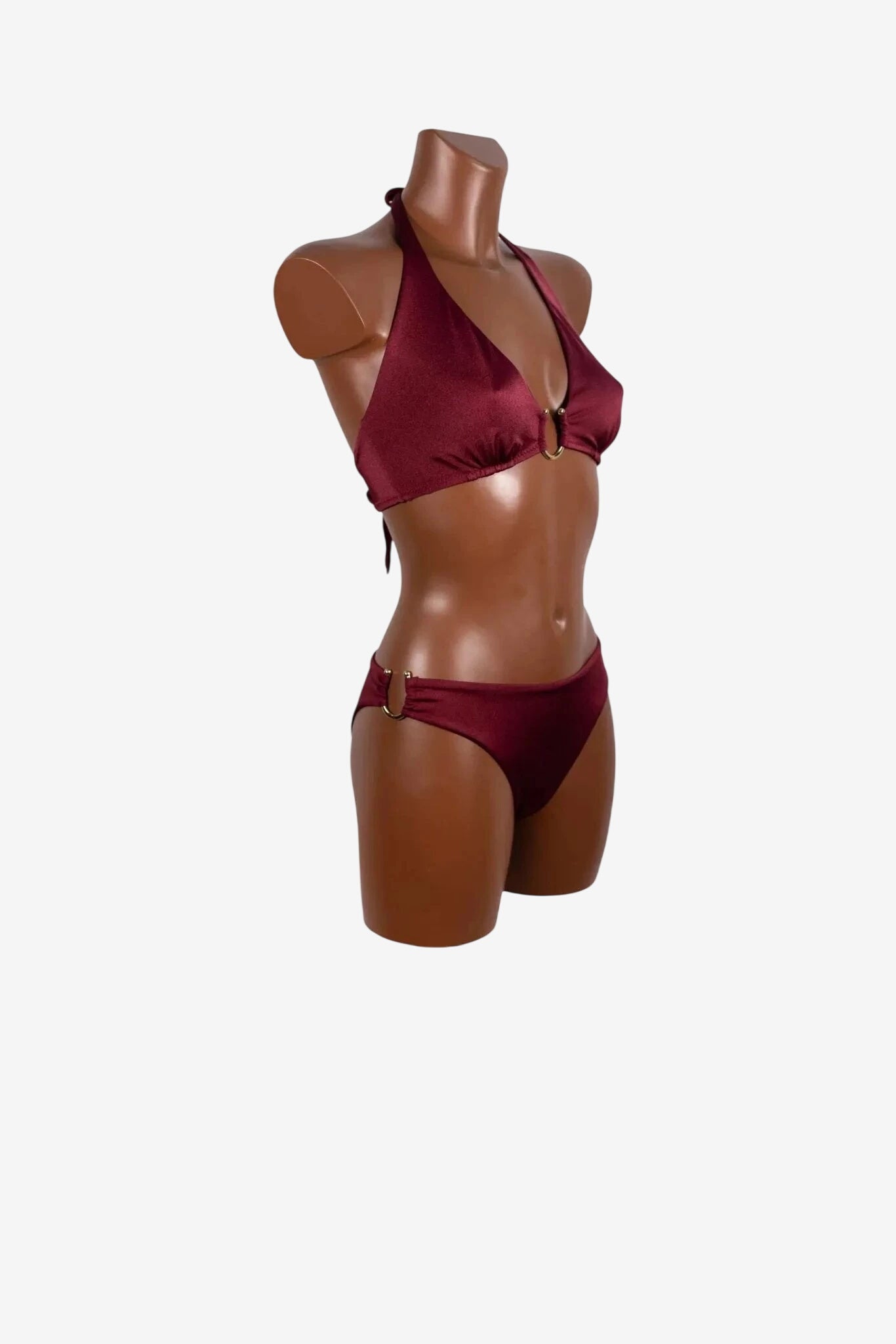 Bikini a vela color bordeaux con dettagli ad anello dorato su un manichino.