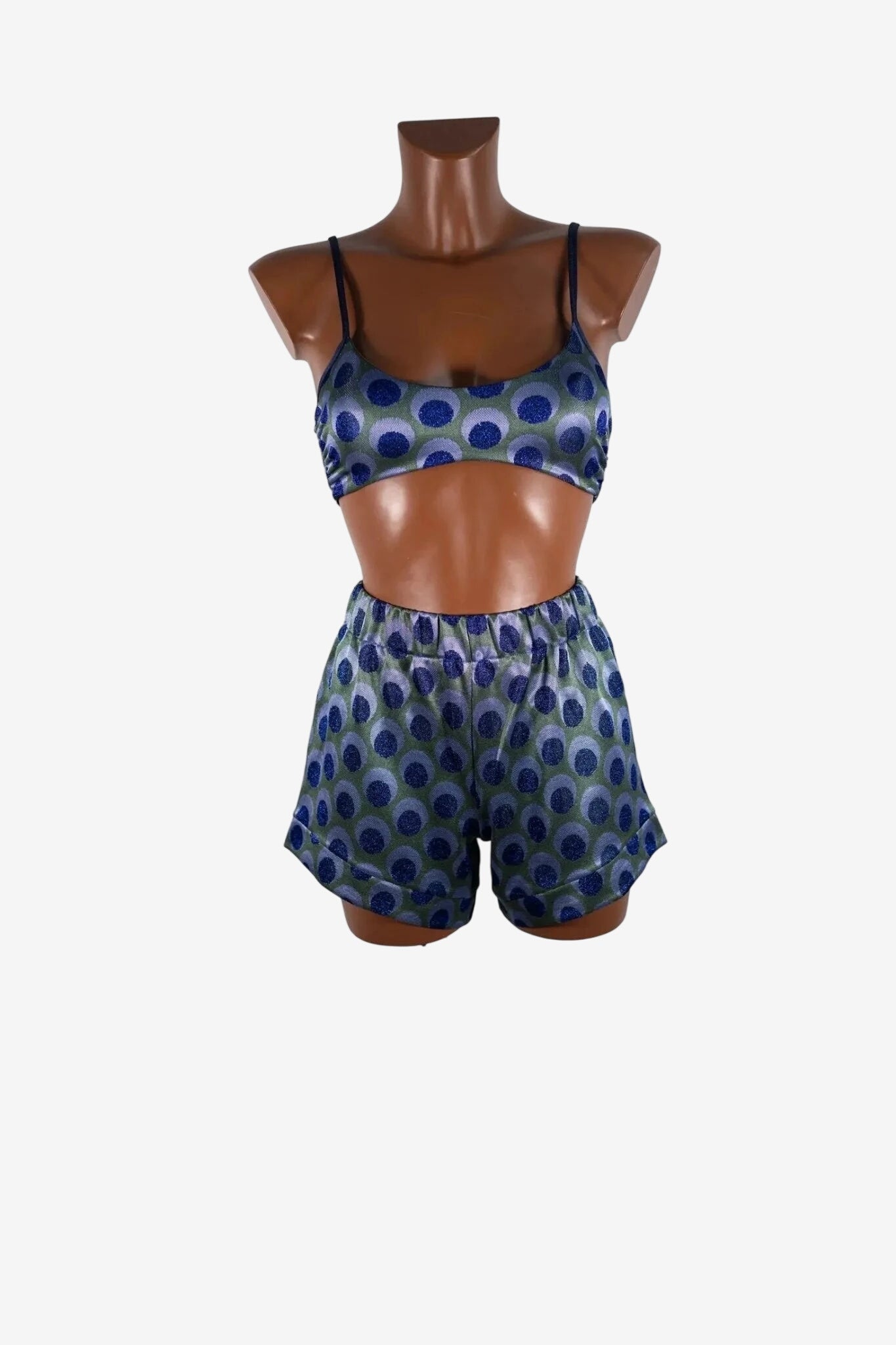 Completo composto da brassiere e pantaloncini con fantasia a pois blu e verde su manichino.