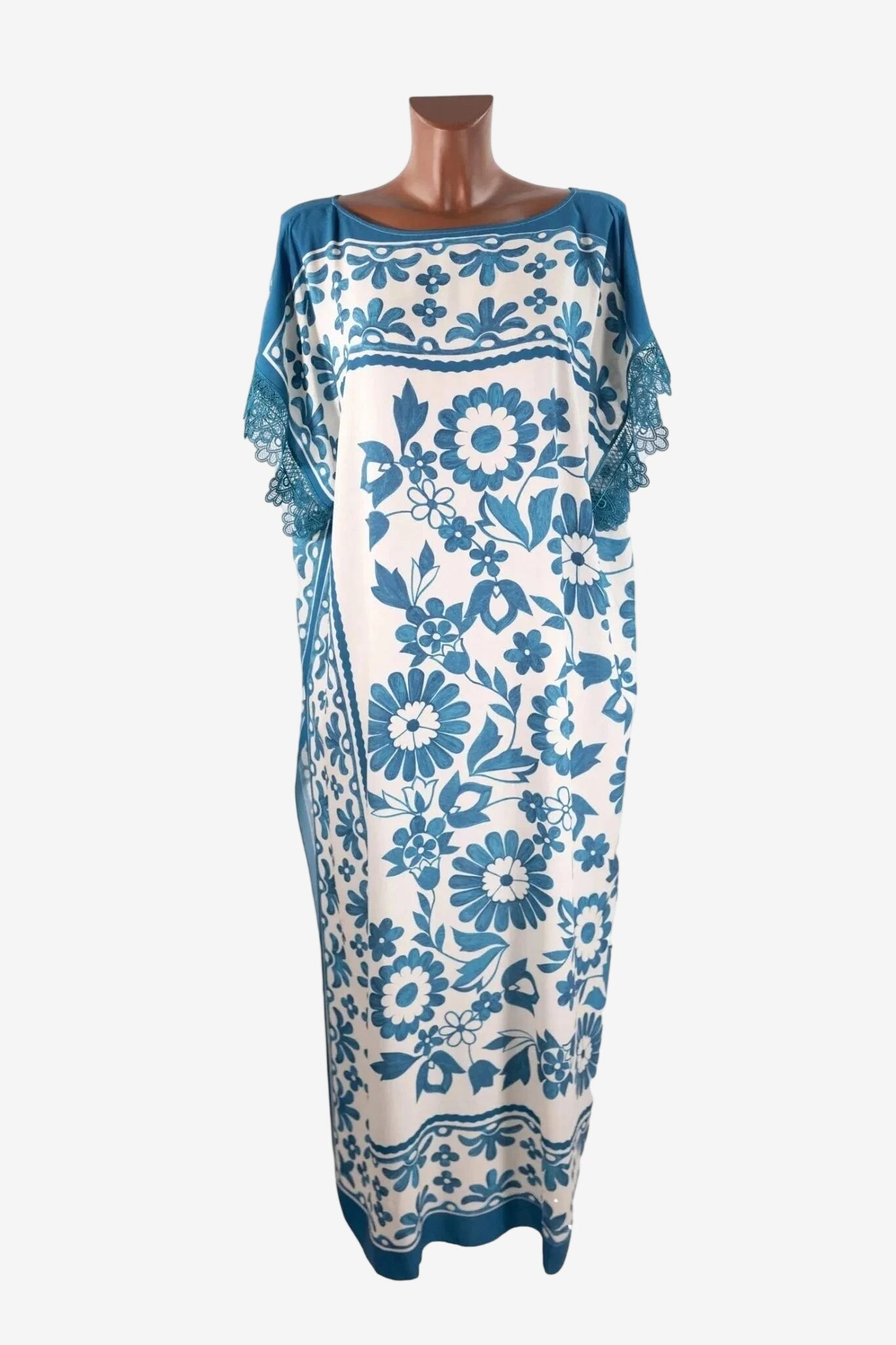 Caftano lungo in viscosa bianca con stampa floreale blu e dettagli in pizzo sulle maniche.