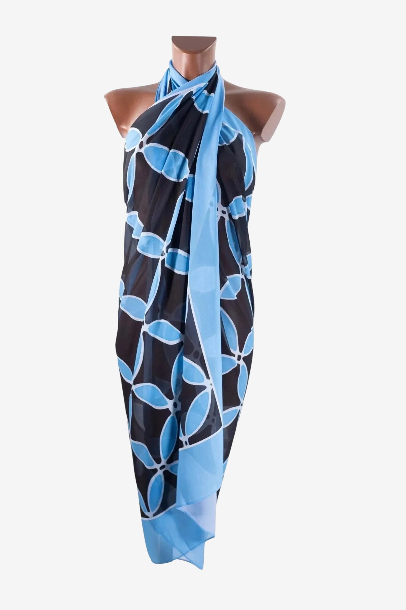 A blue and black floral print pareo is draped over a mannequin.