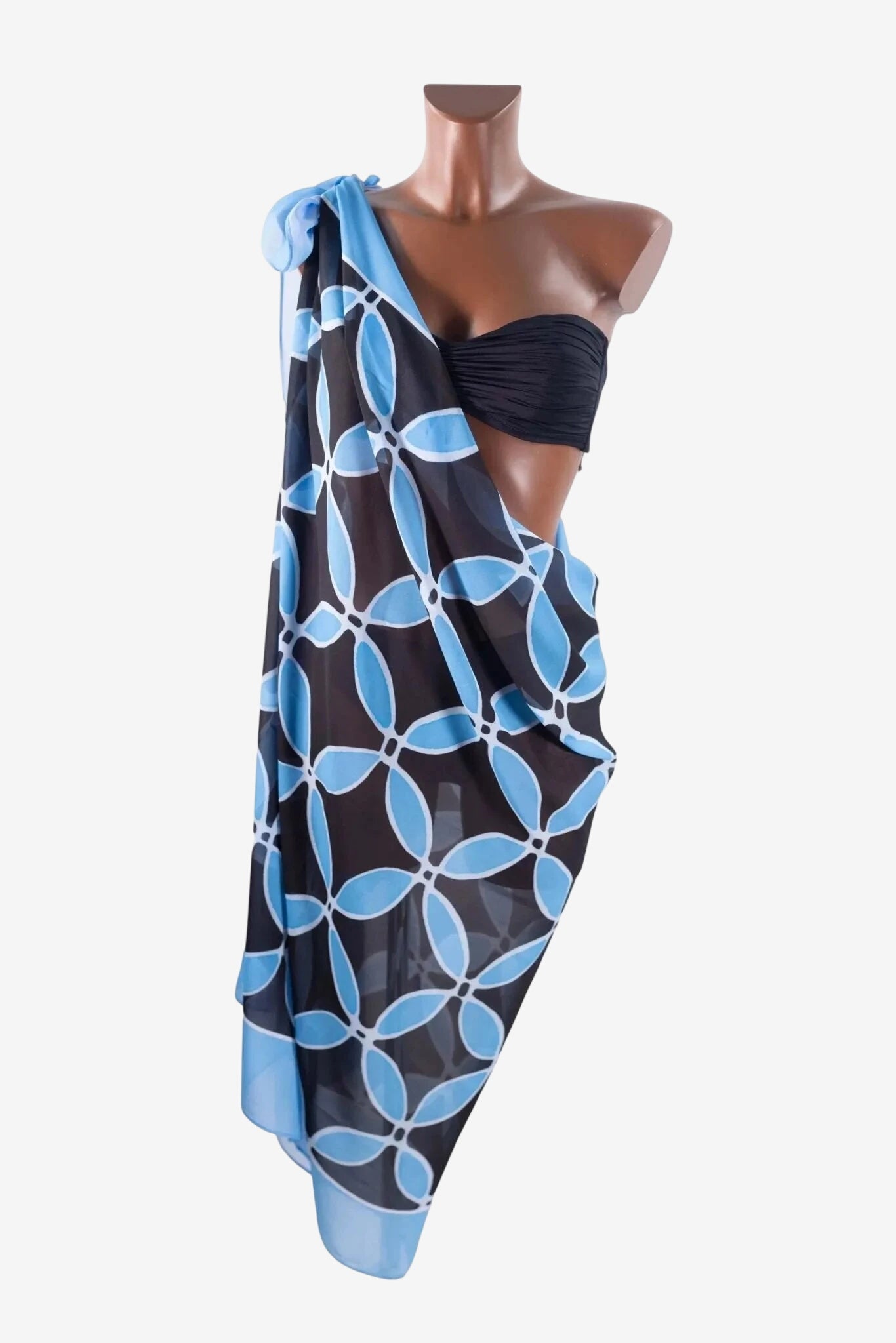A black and light blue floral patterned pareo draped over a mannequin wearing a black bikini top.