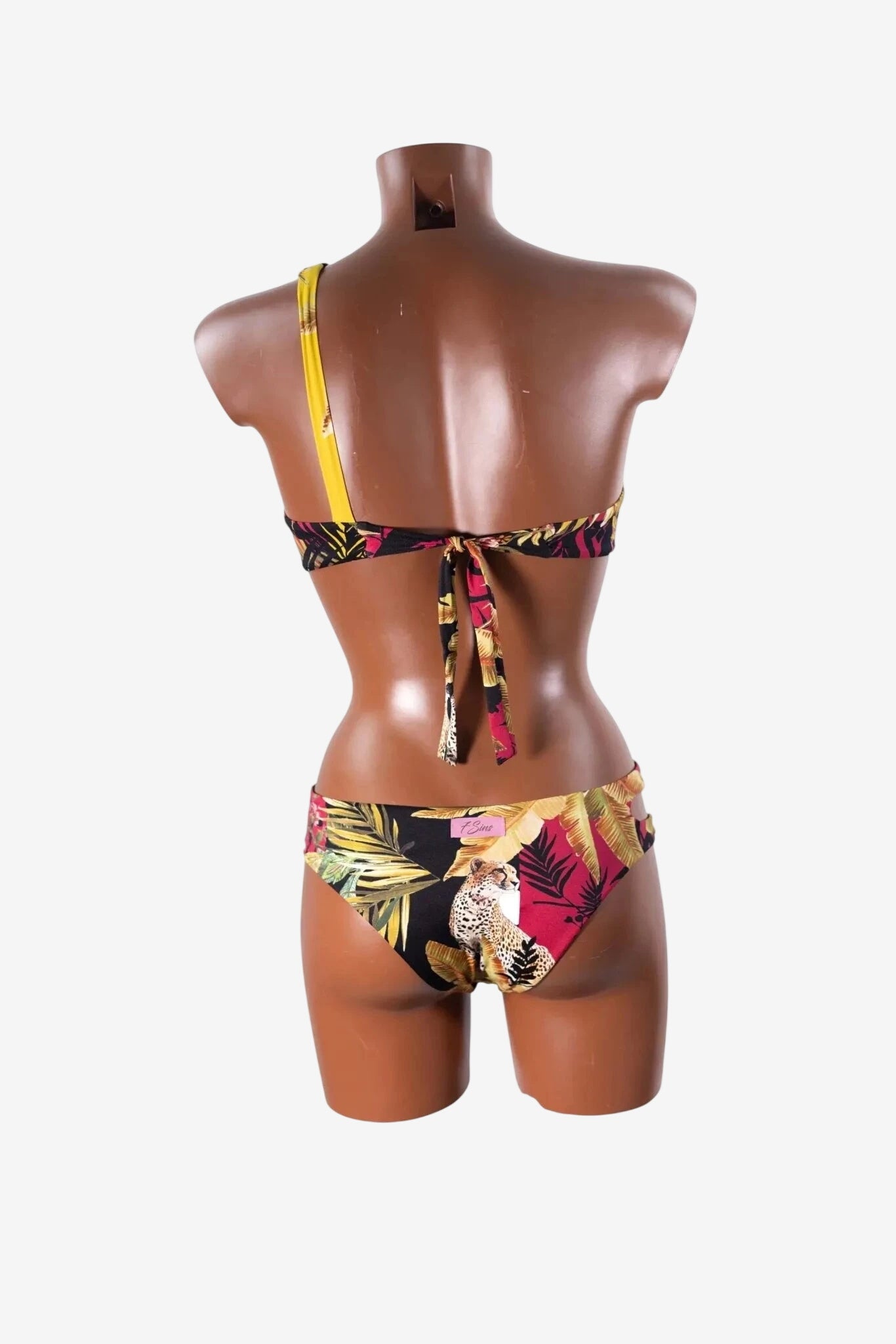 Costume intero Miss Bikini con stampa tropicale e leopardo su manichino visto da dietro.