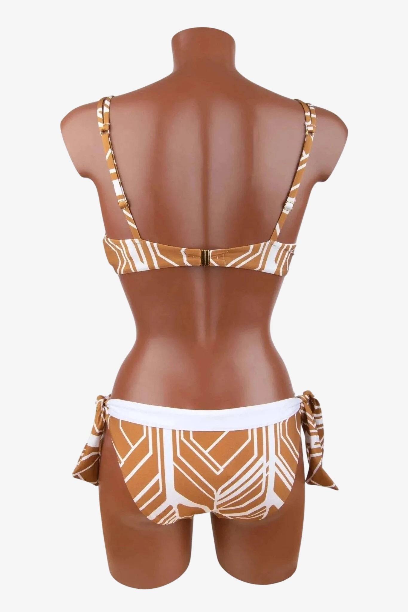 Vista posteriore di un bikini bicolore con fantasia geometrica, spalline regolabili e slip a fiocchi.