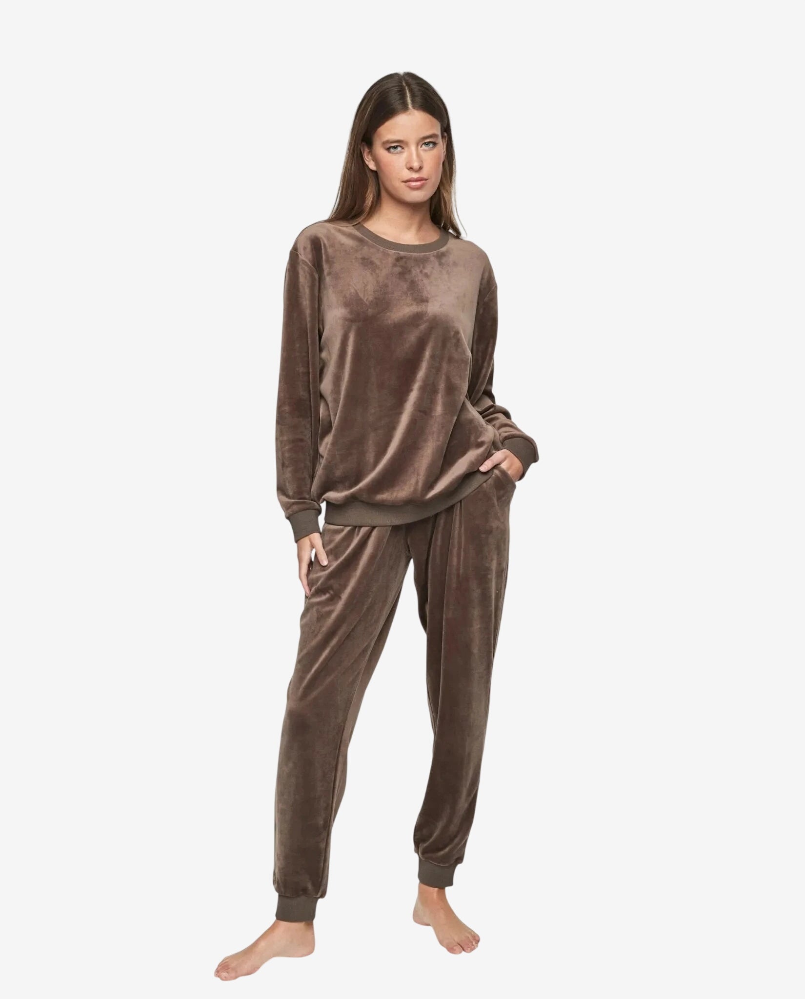 Modella che indossa una tuta in ciniglia color tortora composta da felpa e pantaloni coordinati.