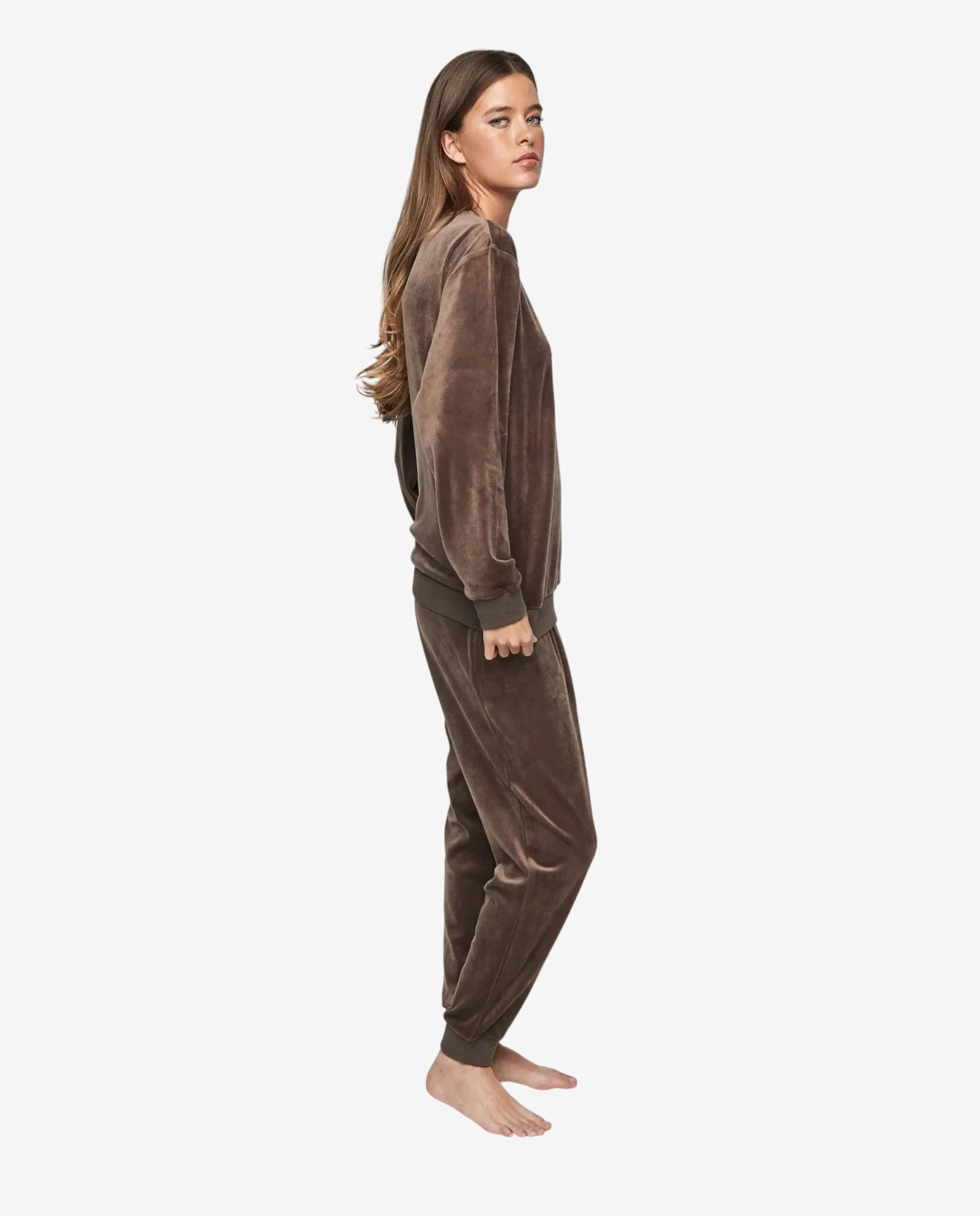 Modella indossa una tuta in ciniglia color tortora composta da felpa e pantaloni coordinati.