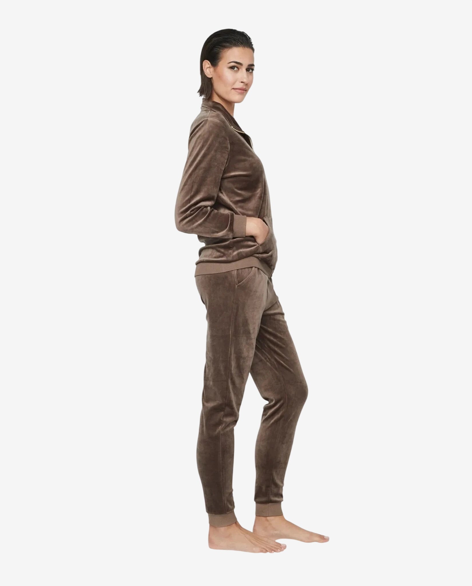 Modella indossa una tuta in ciniglia marrone con zip e pantaloni coordinati.
