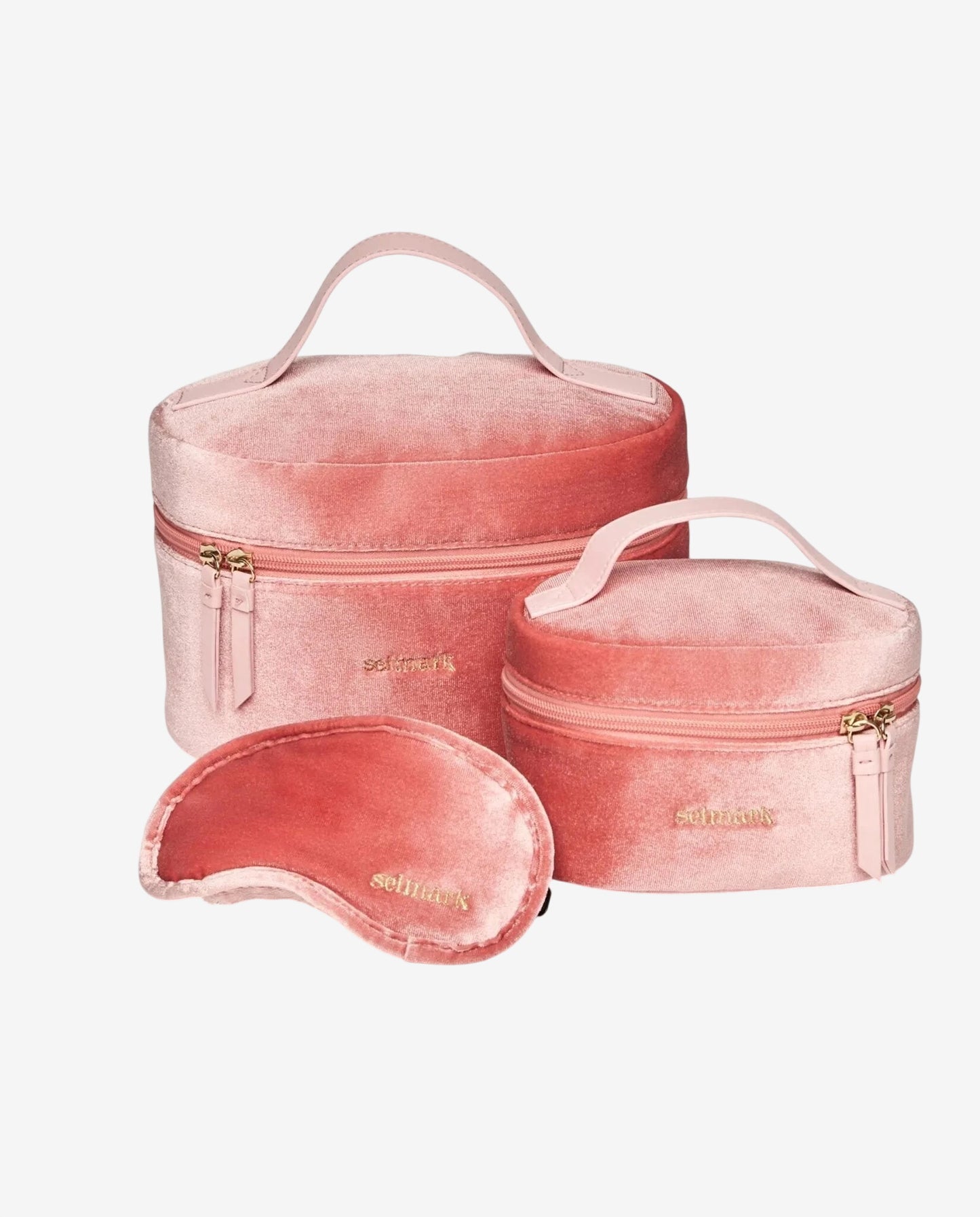 Set di due beauty case in velluto rosa e una mascherina per dormire coordinata.