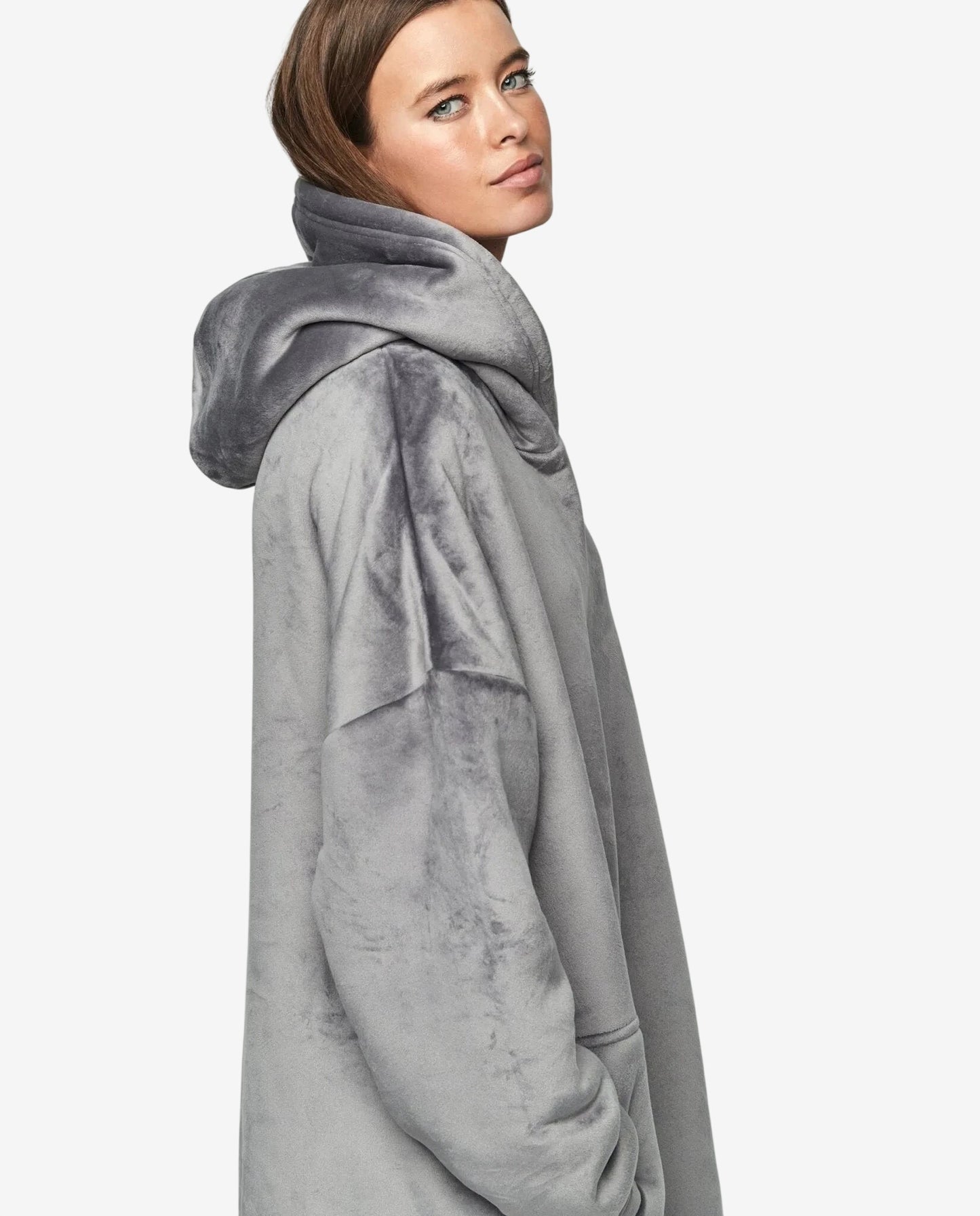 Modella indossa un abito oversize grigio in morbido tessuto con cappuccio.