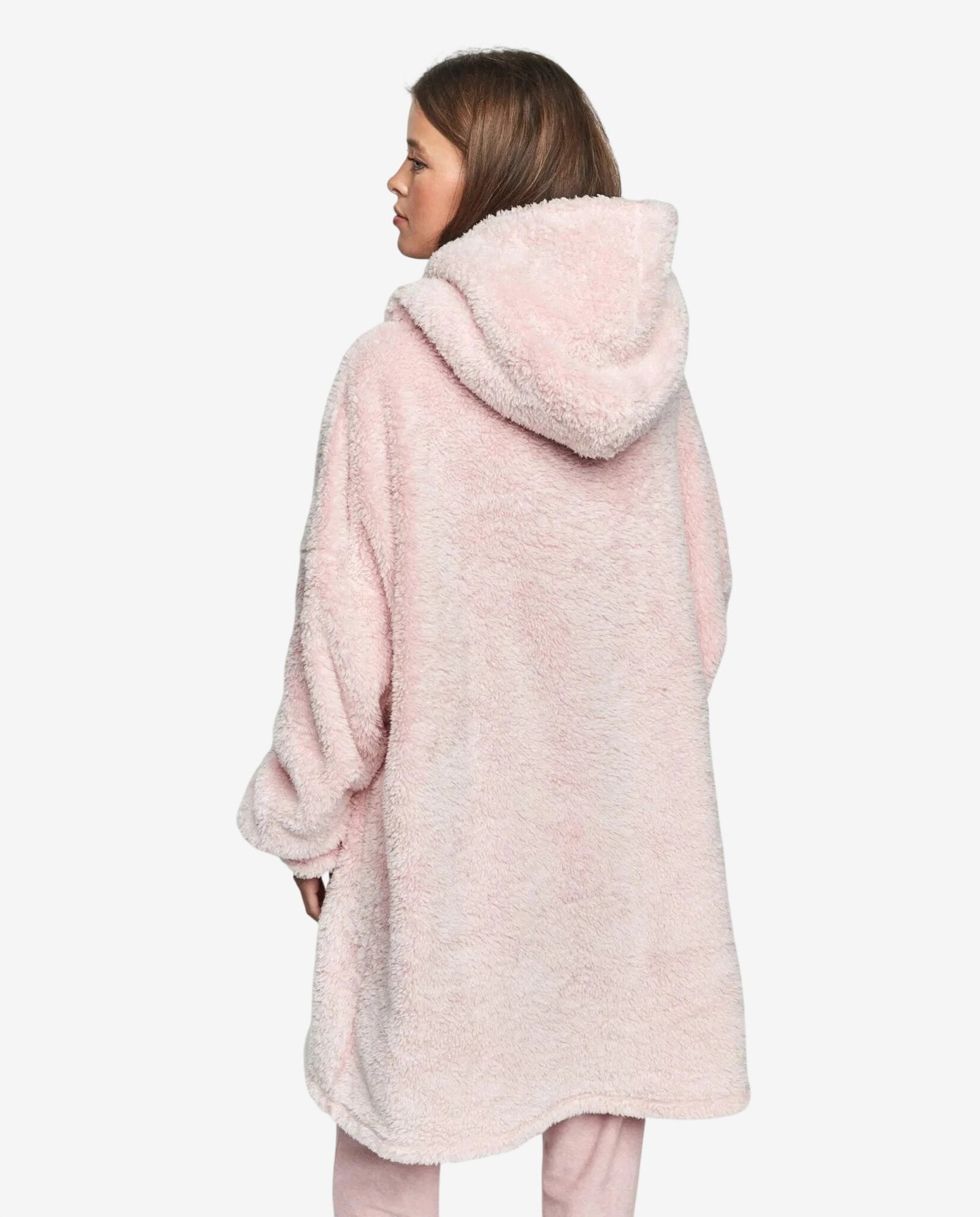 Una persona indossa un abito oversize rosa in morbido tessuto felpato con cappuccio.