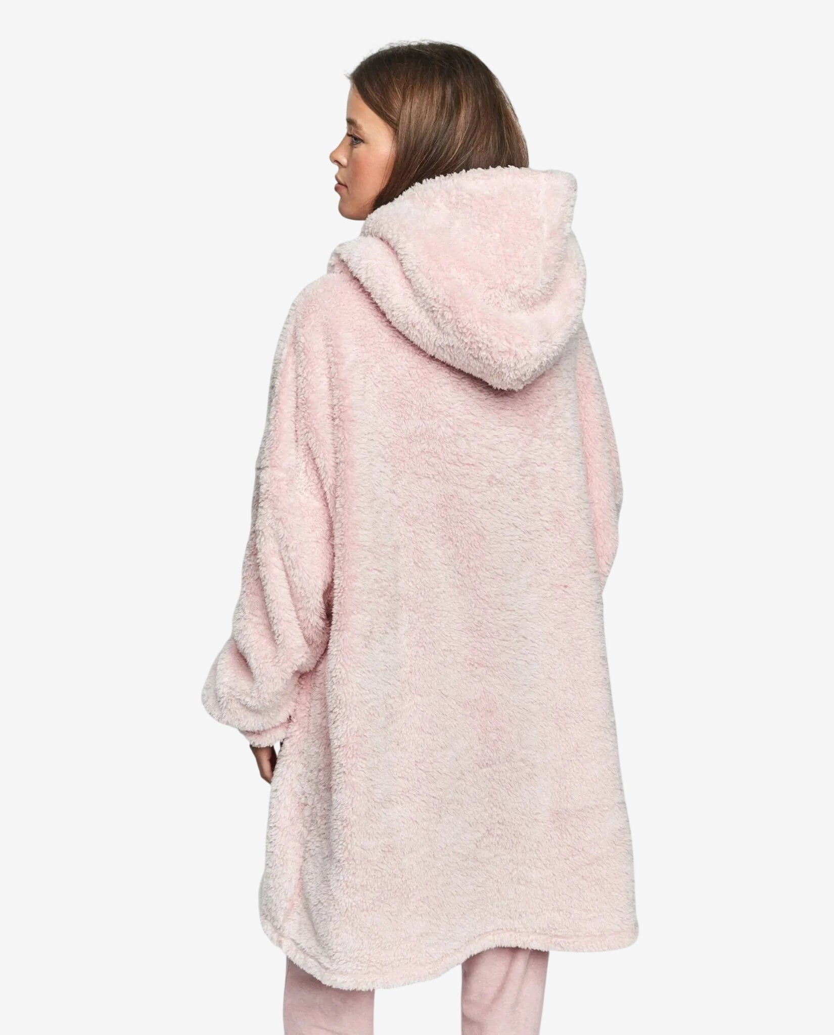 Una persona indossa un abito oversize rosa in morbido tessuto felpato con cappuccio.