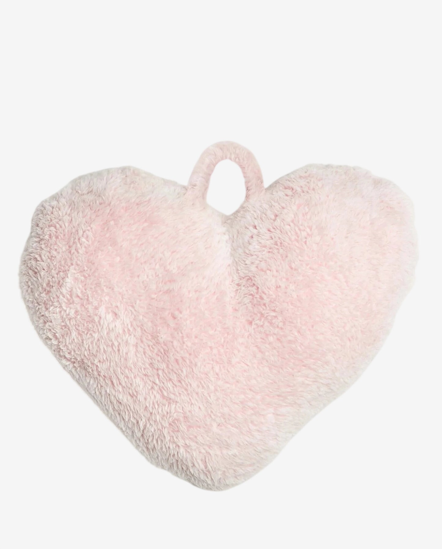 Un cuscino a forma di cuore in morbido tessuto peluche di colore rosa chiaro.