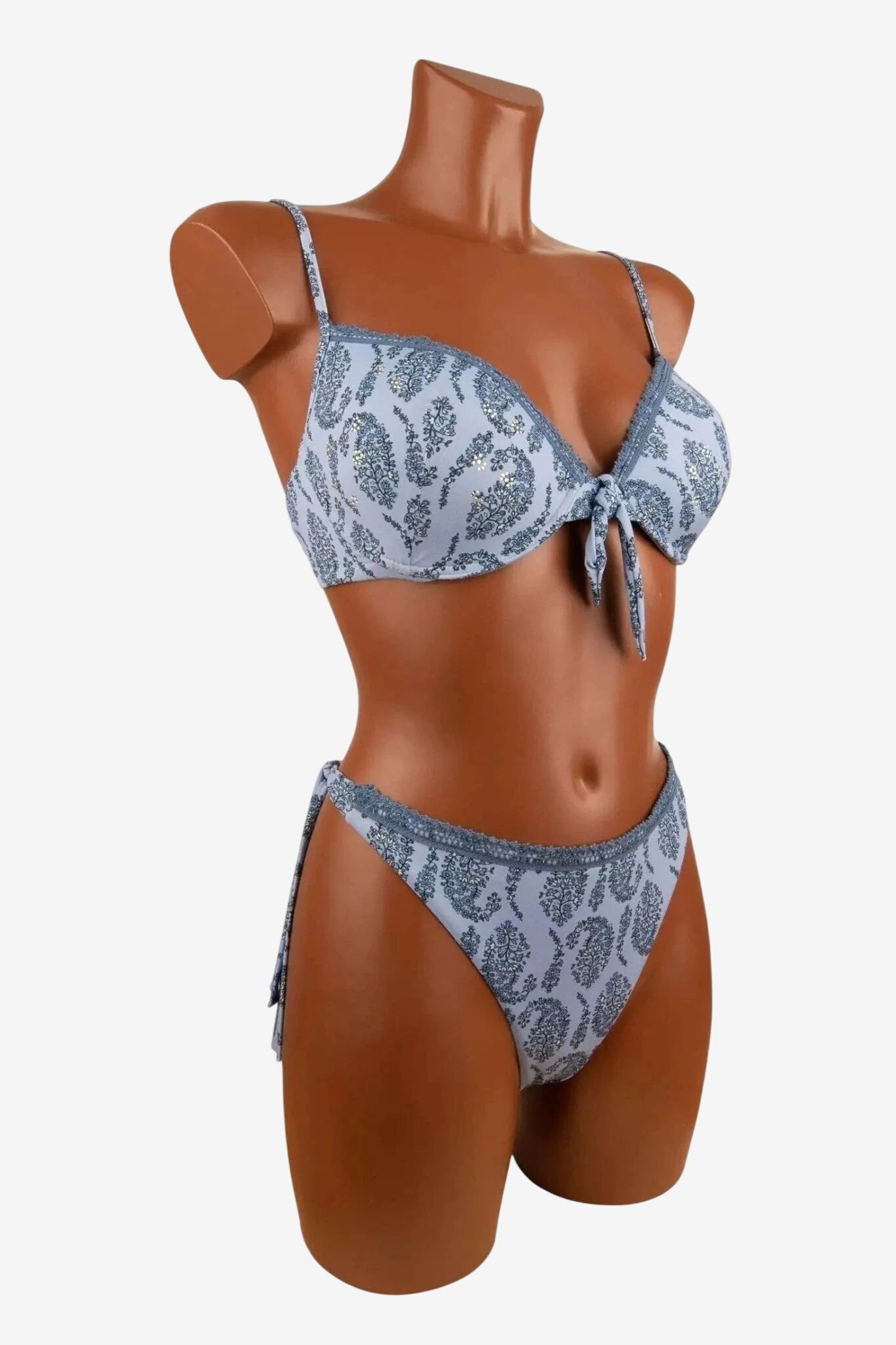 Bikini push up celeste con fantasia cachemire, ferretto e slip sgambato con laccetti laterali.