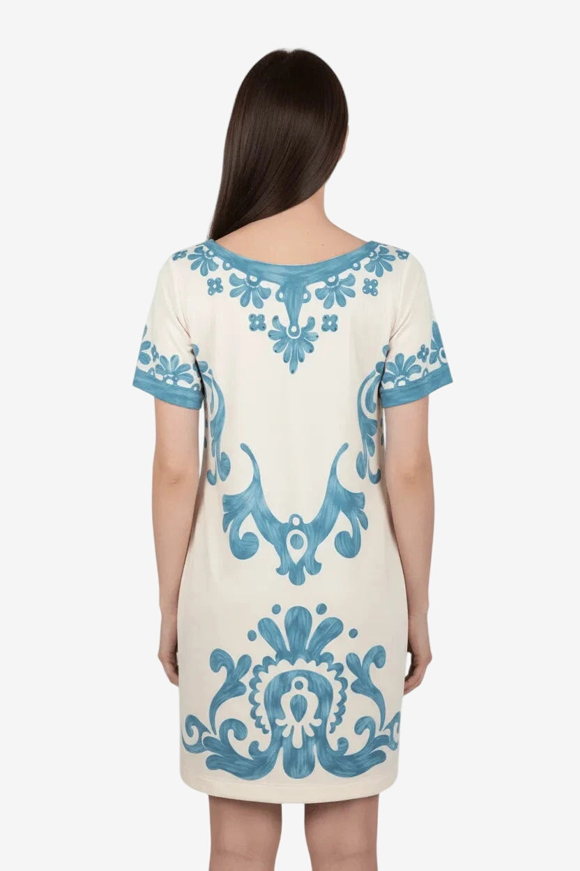 Abito corto in lycra color crema con stampa floreale blu e dettagli in strass.