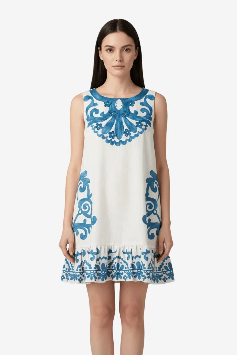 Abito corto smanicato bianco con decorazioni floreali blu e applicazioni di strass.