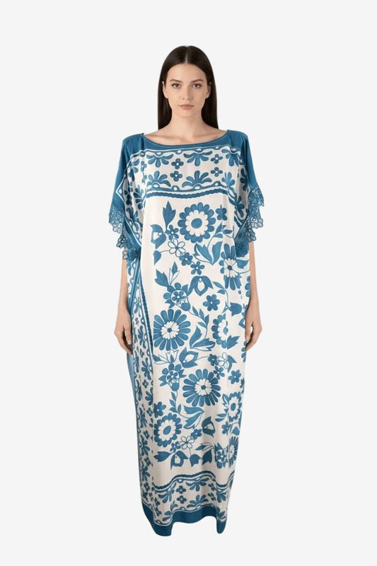 Caftano lungo in viscosa bianca con stampa floreale blu e dettagli in pizzo macramè sulle maniche.