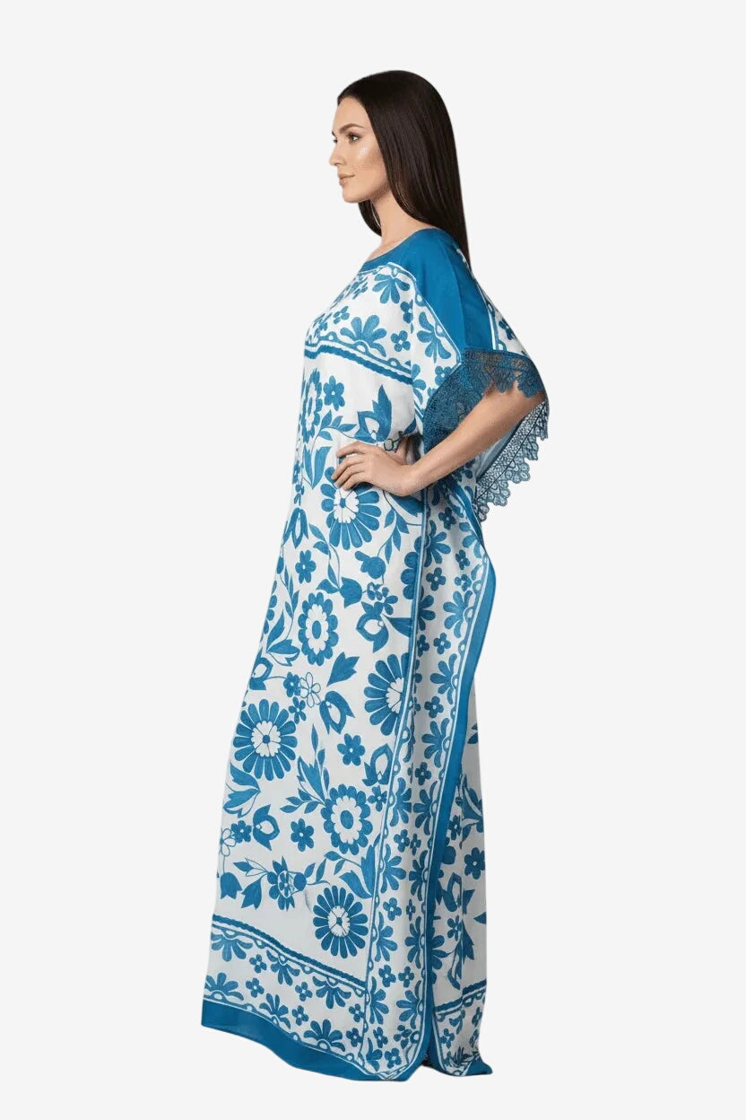 Caftano lungo in viscosa bianca e blu con stampa floreale e dettagli in pizzo sulle maniche.