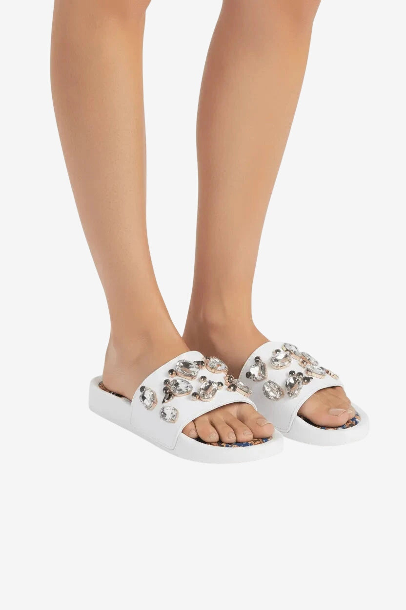 Ciabattina bianca bassa decorata con pietre preziose e plantare in tessuto a fantasia.