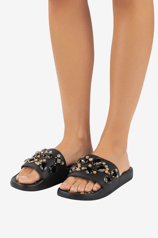 Ciabattina bassa nera decorata con pietre preziose e plantare a fantasia.