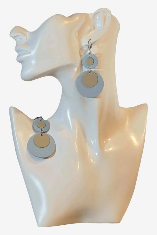 Orecchini pendenti composti da due cerchi in pelle color azzurro e beige su ganci in acciaio.