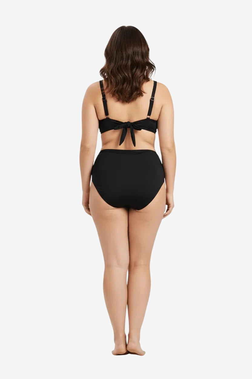 Vista posteriore di un bikini nero a vita alta con chiusura a fiocco sulla schiena.
