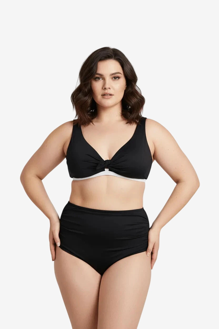 Modella che indossa un bikini nero a due pezzi con top annodato e slip a vita alta arricciato.
