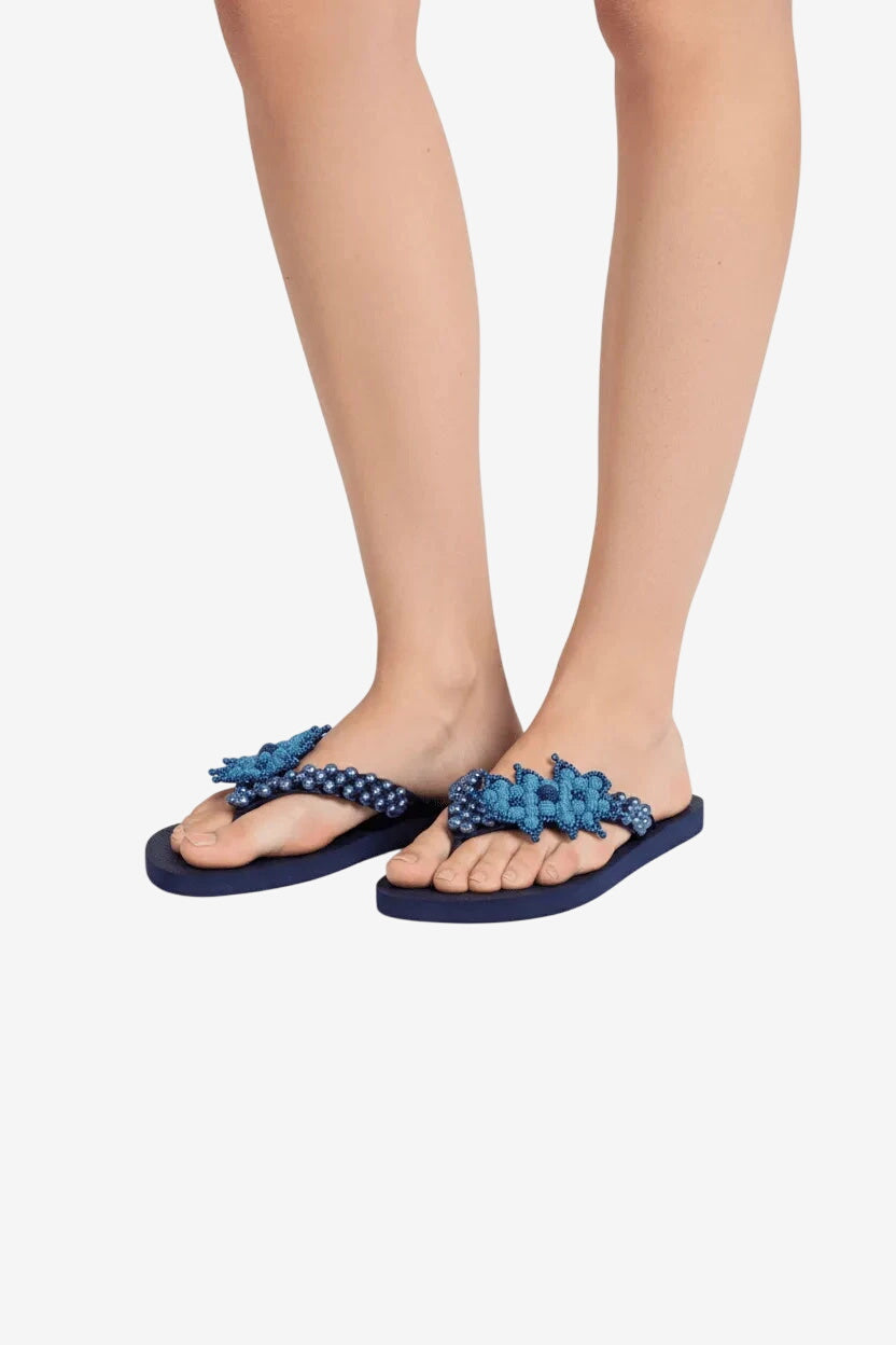 Infradito blu turchese da donna con decorazioni di perline sulla fascia.