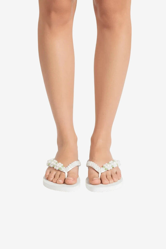 Infradito bianche da donna con decorazioni di perline sul cinturino.