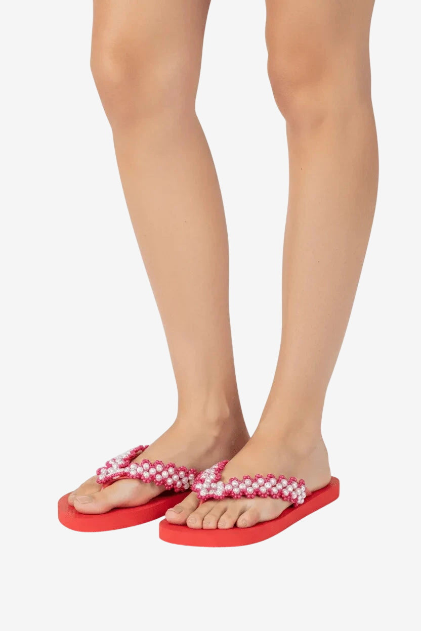 Infradito Havaianas rosse con cinturini ricamati a mano con perle bianche.