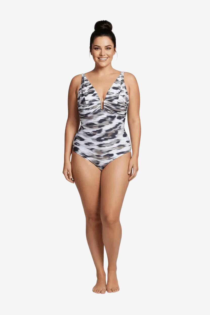 A woman wears a one-piece swimsuit featuring a grey and white abstract animal print pattern.