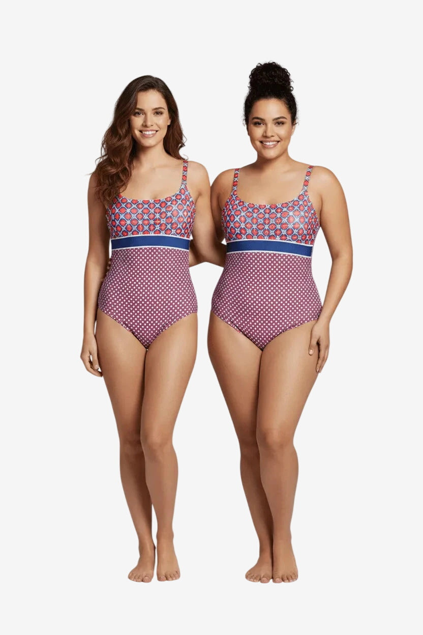 Due modelle indossano un costume intero con fantasia geometrica e pois su sfondo bordeaux.