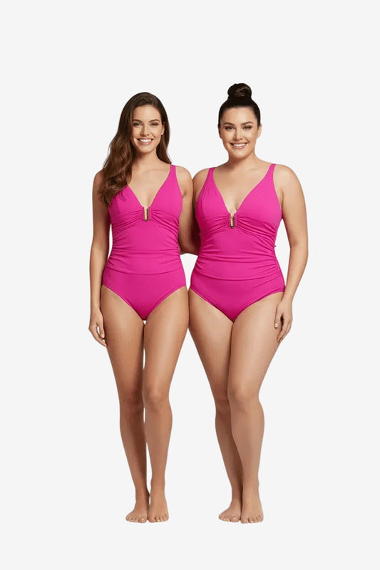 Due modelle indossano un costume intero Roidal color ciclamino con scollo profondo e dettaglio oro.