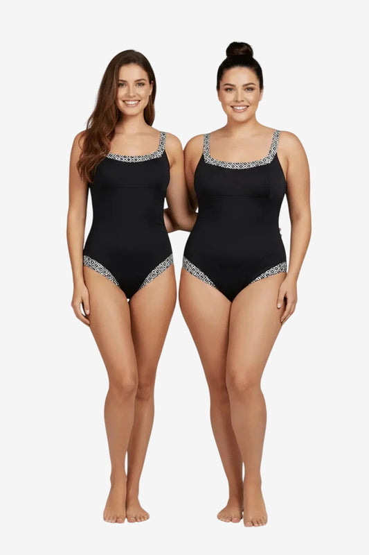 Due modelle indossano un costume intero nero con dettagli geometrici bianchi su scollo e fianchi.