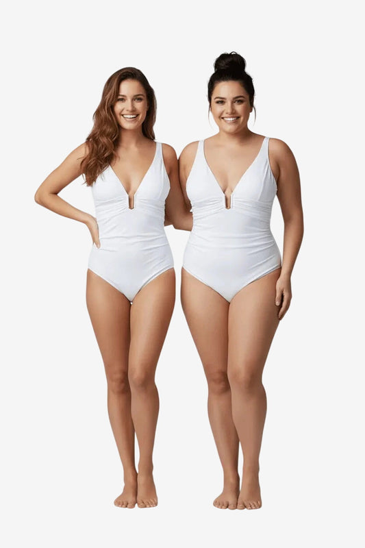 Due modelle indossano un costume intero bianco Roidal con scollo profondo e dettaglio metallico.