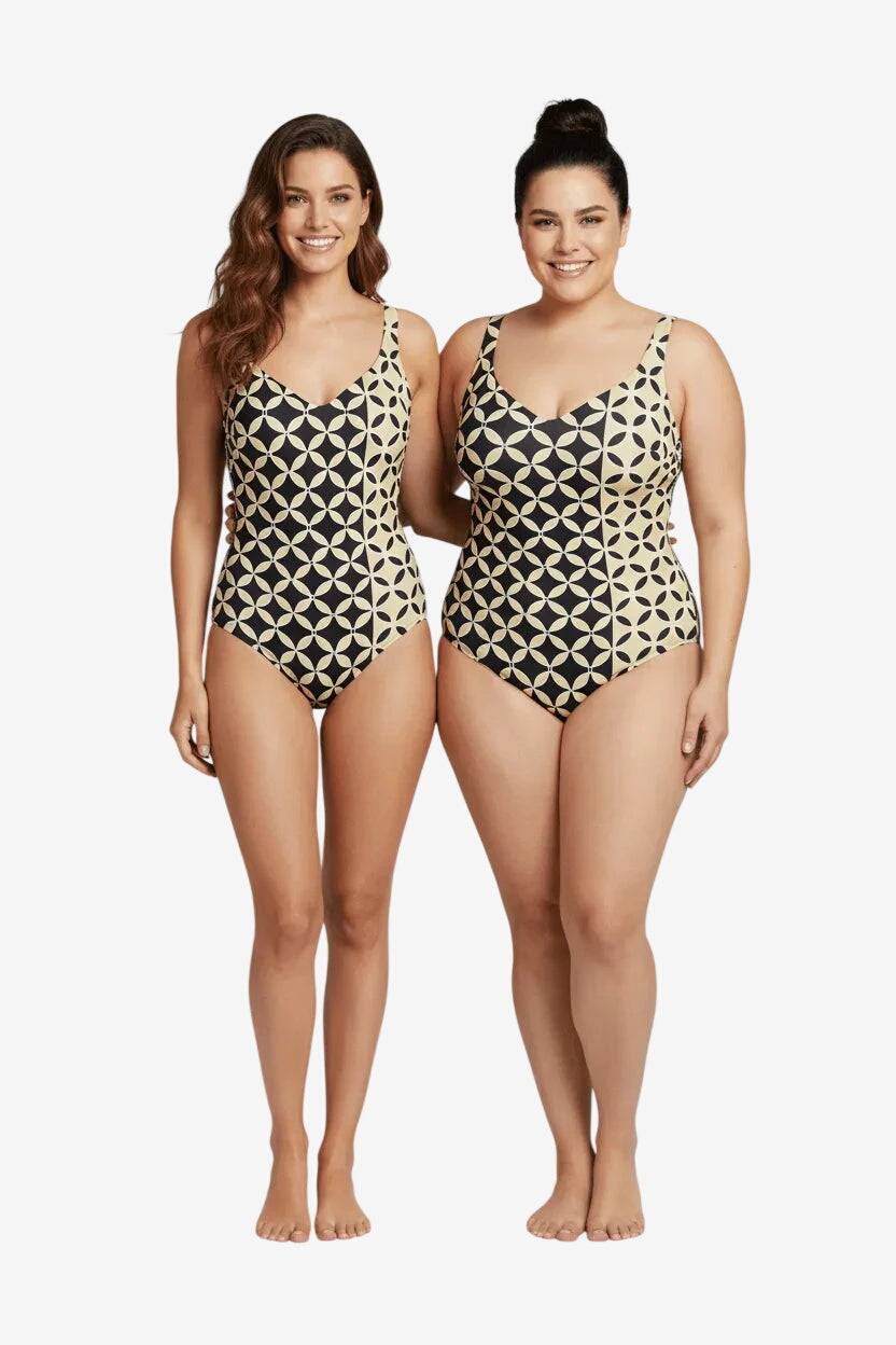 Due modelle indossano un costume intero Roidal con fantasia geometrica color sabbia e nero.
