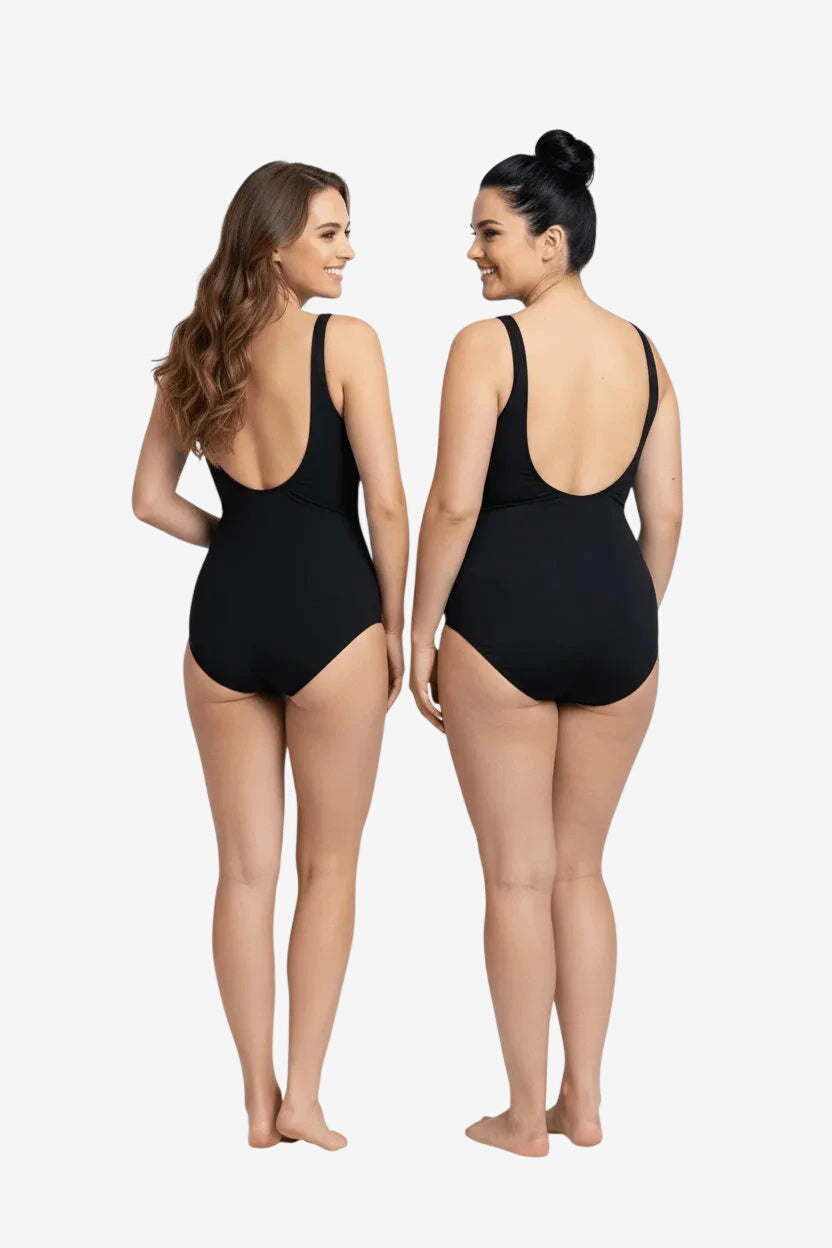 Two women stand back-to-back wearing black one-piece swimsuits with a scoop back design.