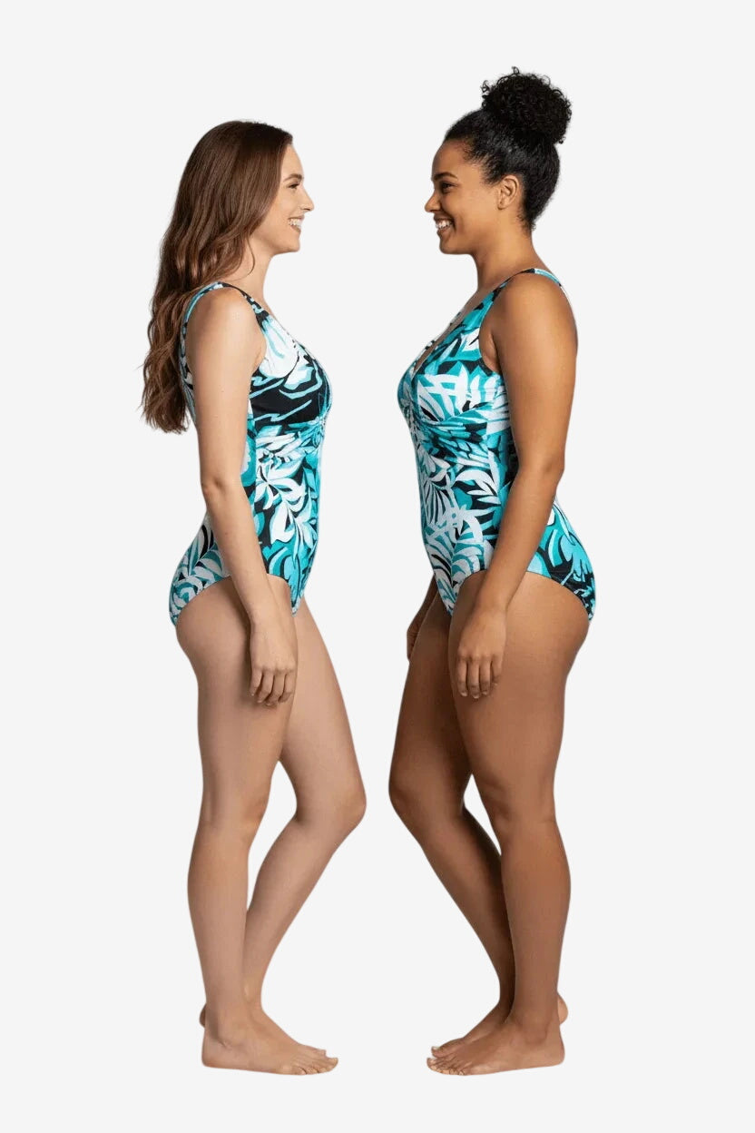 Due modelle indossano un costume intero Roidal con fantasia tropicale nei toni del blu e bianco.