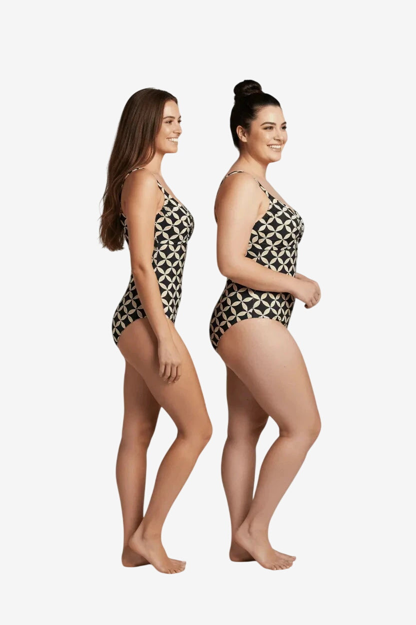 Due modelle indossano un costume intero Roidal con fantasia geometrica color sabbia e beige.