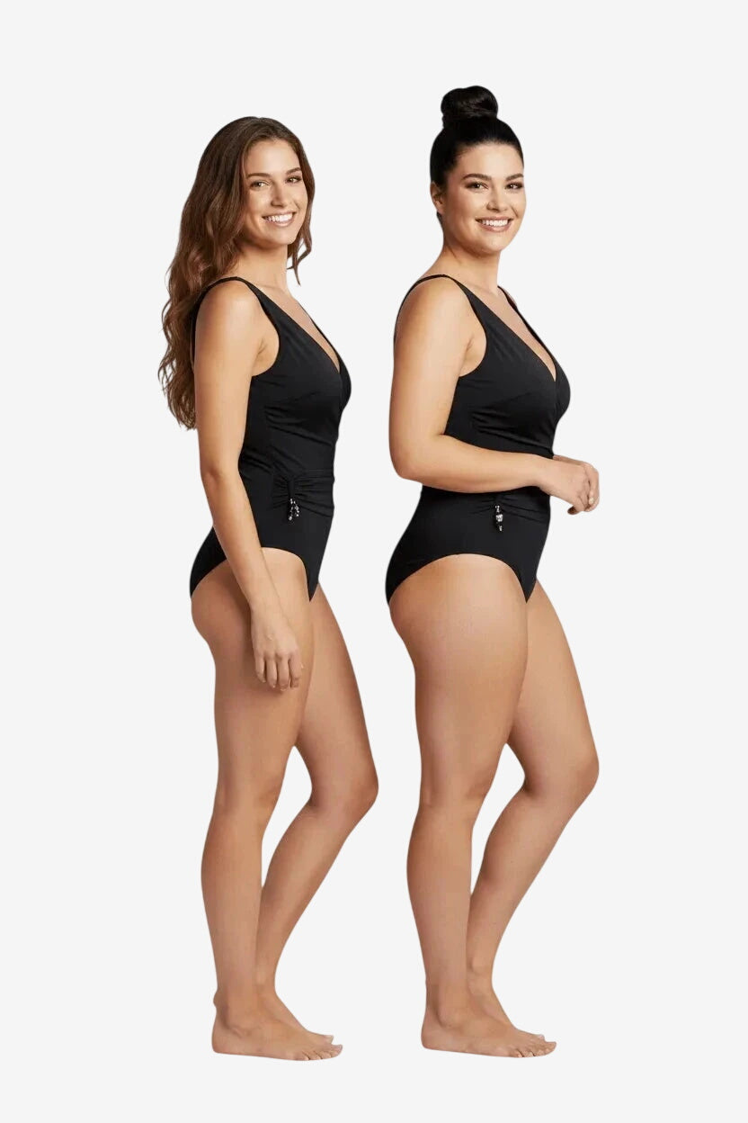 Due modelle indossano un costume intero nero Marette Premium con scollo a V e dettagli laterali.
