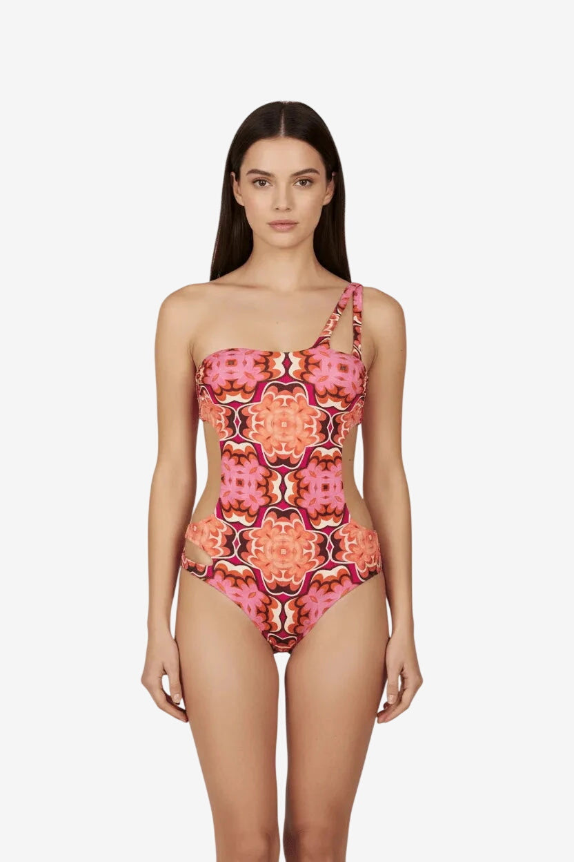 Costume intero trikini monospalla con fantasia geometrica nei toni del corallo e del rosa.