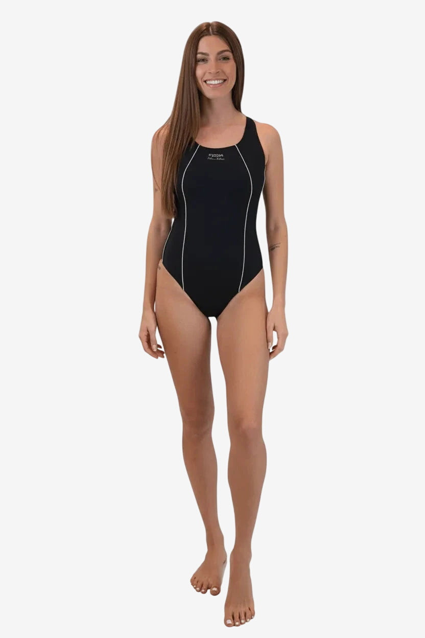 A woman wears a black one-piece swimsuit with white piping details on a white background.